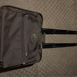 TUMI Black Rolling Briefcase model 26102DH.  Two wheels, extendable handle.
